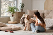 Beautiful young woman with cute fluffy Australian Shepherd dog in living room