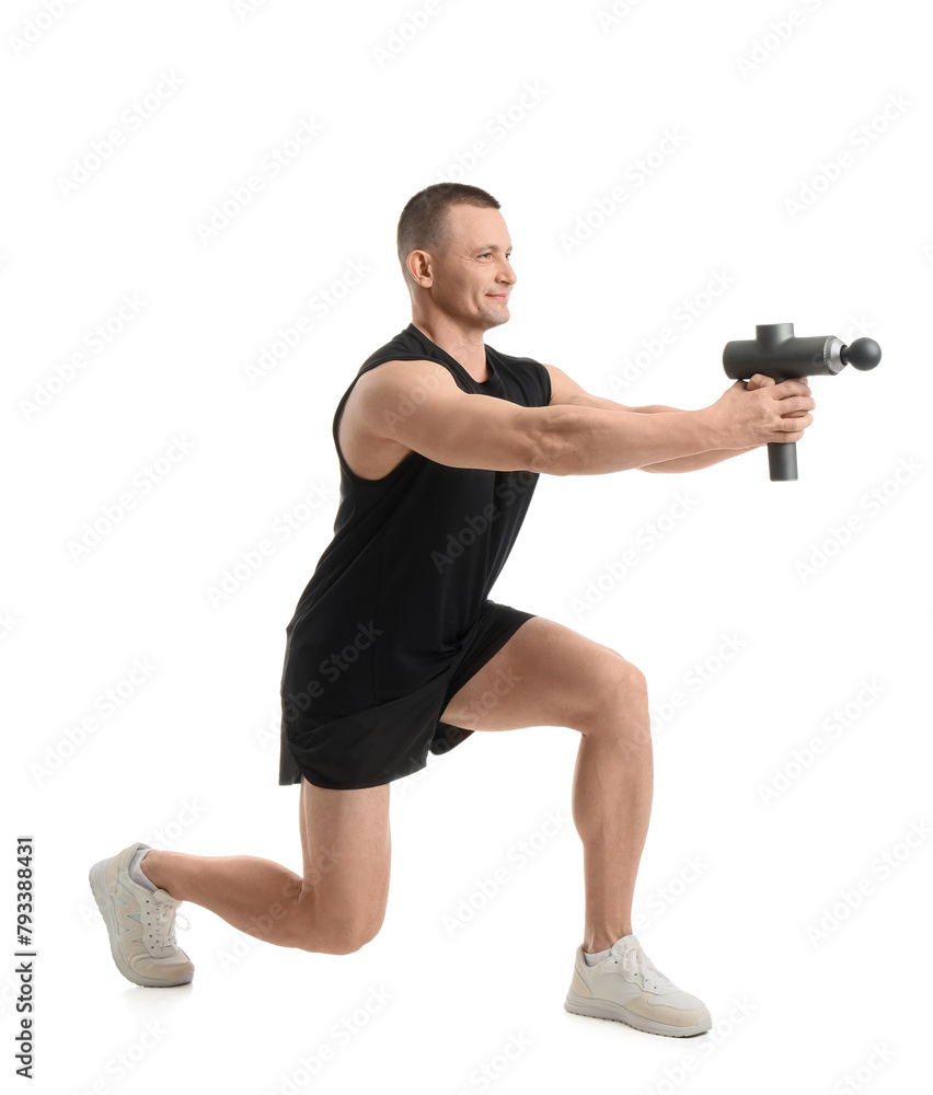 Sporty young man with percussive massager on white background