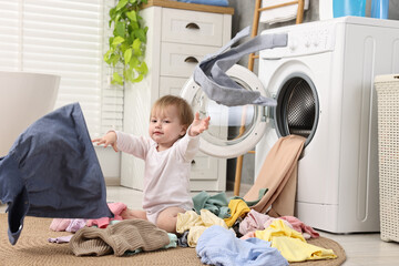 Wall Mural - Little girl scattering baby clothes in bathroom