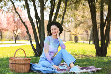 Poster - Beautiful young woman having picnic in park on sunny spring day