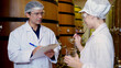 Winemaker team checking and examining producing wine at winery in factory, inspector checking quality and fermenting wine storage in tank or barrel at room, industrial and manufacture concept.