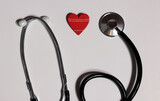 Fototapeta Kosmos - Stethoscope and red heart on white background. Cardiology and Healthcare concept.