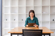 Portrait of Young asian business woman using tablet, standing in the office workplace.