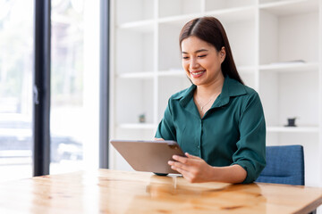 Portrait of Young asian business woman using tablet, standing in the office workplace.