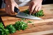 Chef dicing fresh herbs with a kitchen knife
