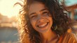 Smiling young woman with curly hair in sunlight