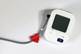 Fototapeta Kosmos - Red Heart and Blood Pressure Monitor Heart Disease Diagnostic Concept. Digital blood pressure monitoring device and heart on a white background.