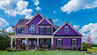 A majestic violet house adorned with siding and shutters stands proudly on a large lot in the suburban subdivision, commanding attention against the vibrant blue sky.