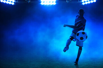 Wall Mural - 3d illustration shadow silhouette of young professional soccer player kicking ball in empty stadium at night