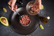 Tuna and avocado tartare recipe - woman fills cooking form with sliced chopped tuna fillet
