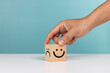 Service rating, satisfaction and positive feedback concept. Hand flip wooden cube change smile face emoticon rating feedback scale
