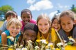 © Iigo - Portrait of group of smiling children lying on grass and looking at camera