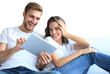 Young couple watching media content online in a tablet sitting on a sofa on a transparent background