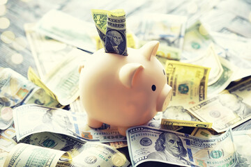 100 dollar bill and piggy bank on money background. Close up. Business, finance, investment, saving concept.