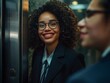 © Iulia - Stunning high resolution photos of a smiling multi-ethnic girl with unique eyes exiting an elevator with a colleague discussing work issues. Business