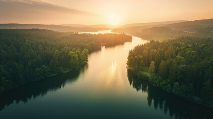 Wall Mural - Aerial view of sunrise over a calm lake surrounded by forest, peaceful morning light on the water