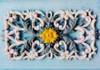 Stucco molding interior corner oriental floral pattern of green marble on old blue painted wall. White cartouche gypsum & natural stone stucco moulding plasterwork abstract background. Decor relief