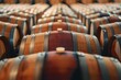This image captures a series of wooden barrels, closely aligned in a winery storage room, highlighting the smooth wooden textures and craftsmanship.