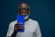 © Markus Schröder - Digital mockup afro-american man in his 60s holding an smartphone with a completely blue screen
