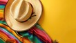 A vibrant yellow backdrop adorned with a classic Mexican Sombrero and colorful serape blanket providing ample space for text or graphics