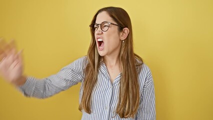 Poster - Furious young woman with blue eyes, screaming in aggression and frustration; enraged expression isolated in yellow background