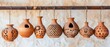© Image - clay pots with cut out patterns hanging from metal bars, light background, clay and terracotta