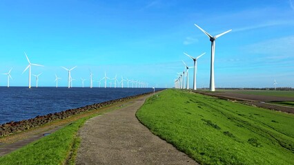 Wall Mural - Windmill park in Spring, windmill turbines generating green energy electrically, windmills in the Noordoostpolder Netherlands on the Dike and in the water