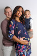 Multiracial couple with a young child in their arms and her pregnant
