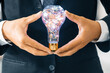 Businessman holding glowing light bulb in hands. Concept of business creativity and ideas. uds