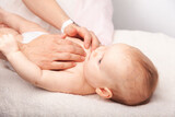 Fototapeta  - Little baby receiving chiropractic treatment of her chest