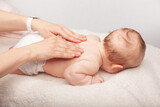 Fototapeta  - Baby chiropractic back treatment