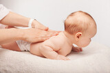 Fototapeta  - Baby chiropractic back treatment