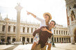 Happy young couple traveling in Venice, Italy - Cheerful tourists visiting venetian landmarks on a sightseeing european tour