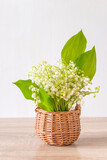 Fototapeta Krajobraz - May Day greeting card template; Bouquet of lilies of the valley in wicker basket on a white background