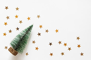 Wall Mural - new year background with christmas tree and star confetti on a light white background. festive xmas 