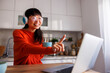 Woman drinking coffee and having online meeting while working from home
