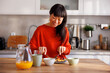 Woman relaxing while having breakfast at home