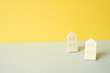 Wooden house model on gray and yellow background. Real estate concept
