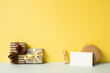 Gift boxes and wrapping accessory on gray desk. yellow wall background