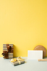 Wall Mural - Gift boxes and wrapping accessory on gray desk. yellow wall background