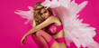 Beautiful sexy blonde woman in elegant lingerie and angel wings is sensually posing on pink background in studio. Angel in lingerie.