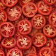 Fondo con detalle y textura de multitud de rodajas de tomate con aspecto fresco