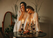Art photo portrait real people couple two women vintage old style clothes, white lace silk dress. Fantasy Sexy girl fashion model in Classic room candles burning glass red wine on table. Vampire woman