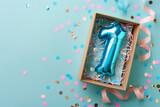 Fototapeta Tęcza - First birthday gift box with number 1 balloon inside, confetti and ribbons on a pastel background