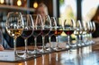 A series of wine glasses filled with red and white wines are lined up for a tasting event at a modern restaurant. Reflective surfaces and soft lighting enhance the ambiance.
