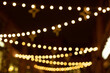 Christmas lights on the street blurred background, hung garlands with yellow lights