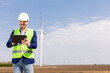 Smiling Engineer With Tablet Inspecting Wind Turbines On A Sunny Day. Generative AI