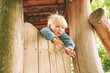 Outdoor portrait of adorable 4 - 5 year old little boy playing on playground
