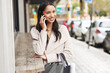 Happy, woman and shopping in city with phone call to contact with news, info and announcement. Girl, customer and travel on street with smartphone chat to virtual communication on holiday or vacation