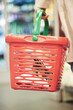Person, hands and shopping with grocery basket, cart or bucket for food, ingredients or snacks in supermarket. Closeup of customer, consumer or shopper buying stock, supplies or groceries at store